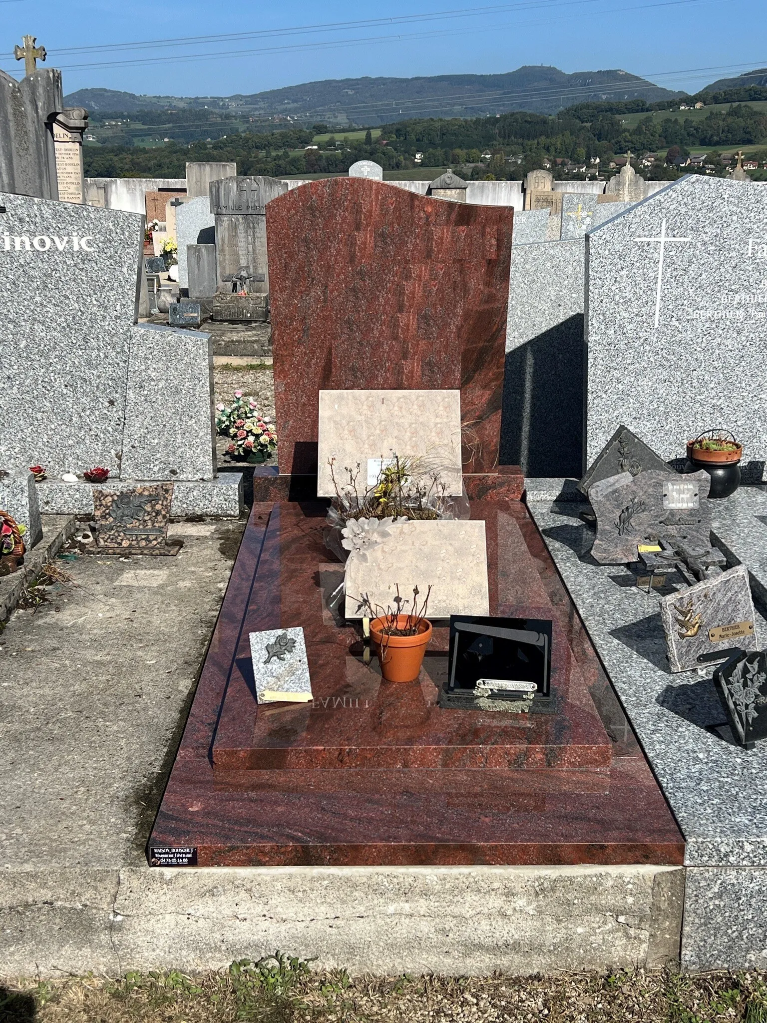 Sépulture familiale en granit rouge poli avec stèle moderne et plaques de souvenir